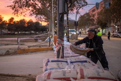 Un hombre coloca sacos de arena para contener una posible nueva riada, este martes en Aldaia.