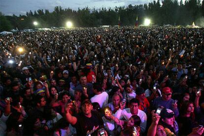 Miles de personas con velas, mecheros y teléfonos móviles rinden homenaje a las víctimas del 11-M durante la fiesta latina celebrada en la Casa de Campo.