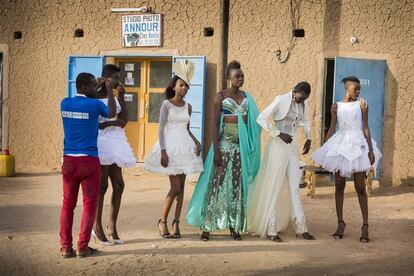 <p>Diciembre 2016. Miriam (segunda por la izquierda) se prepara junto con otras cuatro modelos para una sesión de fotos de moda en el casco antiguo de Agadez, cerca de la gran mezquita. Están vestidas con la nueva colección de Modeste Ba de Costa de Marfil.</p>
<p>La décima edición del FIMA, que tendría que haberse celebrado en Niamey a finales de 2015, fue cancelada en el último momento porque el Ejército no podía garantizar la seguridad del evento. Dicha edición tuvo lugar en diciembre de 2016 en Agadez bajo fuertes medidas de seguridad. Durante una semana, en diciembre, se desarrollaron varios eventos culturales (Sultan de l’Aïr, Grand Marathon du Téneré, desfile de la armada nacional…) en un intento de demostrar que esta mítica ciudad del desierto del Sahara es segura y poder recuperarla para el turismo. Durante los 10 últimos años ha sido considerada una urbe muy peligrosa, por lo que el turismo había desaparecido.</p>