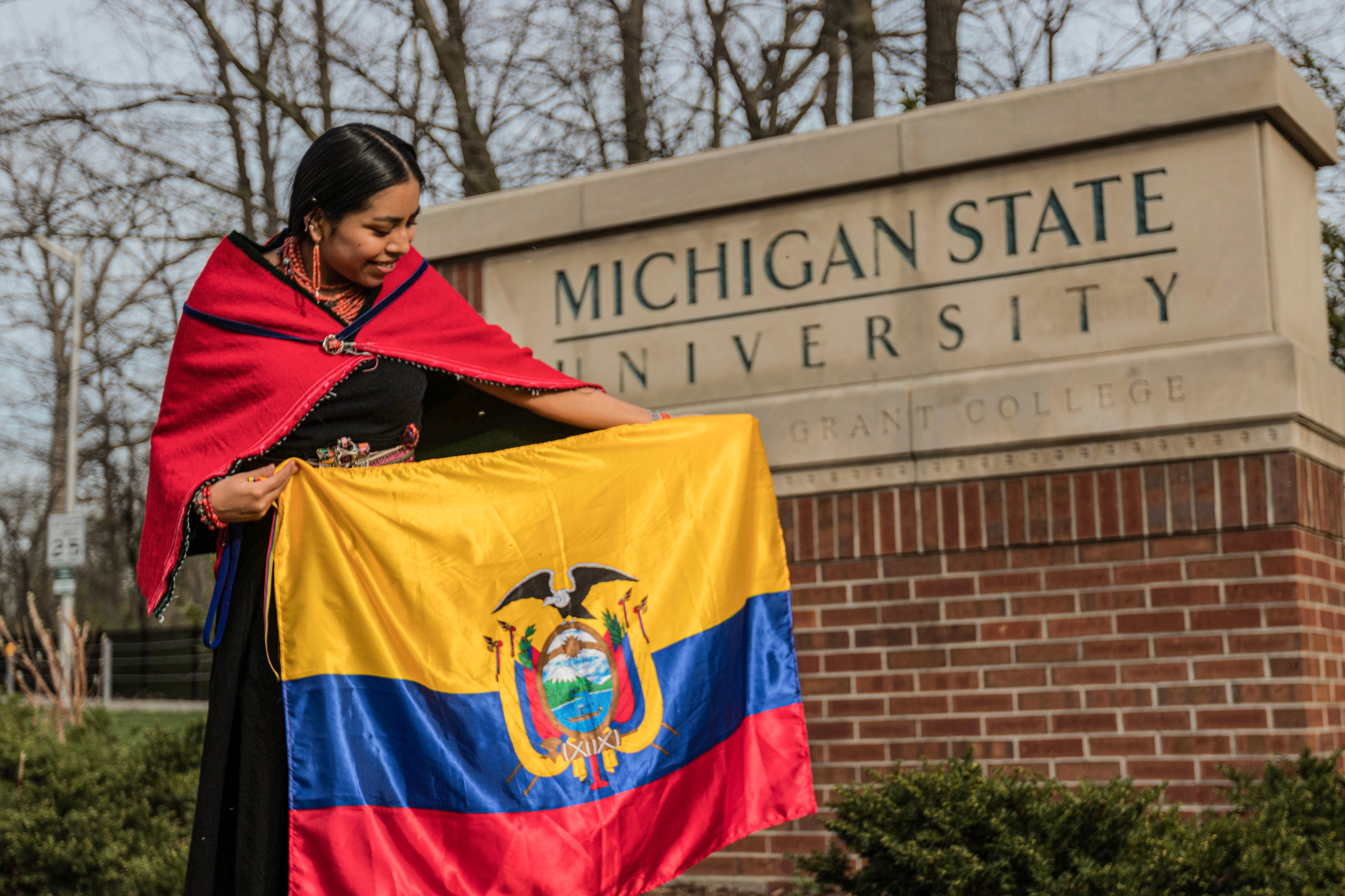 Micaela muestra la bandera ecuatoriana en el campus de la Universidad Estatal de Michigan, en 2024.