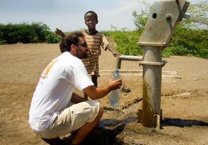 Paco Moreno llena de agua uno de los pozos construidos por su ONG.