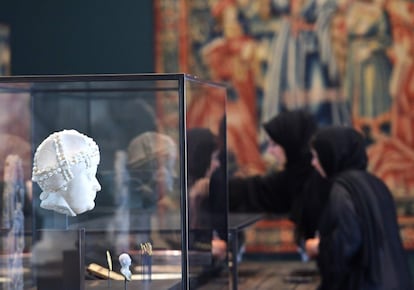 Una mujer observa una estatua expuesta en una galería del Louvre de Abu Dabi durante un pase para prensa. El recorrido, compuesto por unos 600 objetos (la mitad, préstamos franceses y la otra mitad, de la incipiente colección permanente), arranca en el año 6.500 a. C. y termina hoy mismo, con un bajorrelieve de inspiración mesopotámica de la artista de los mensajes lumínicos, Jenny Holzer.