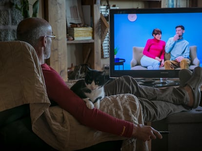 A man looks at a television screen at home.