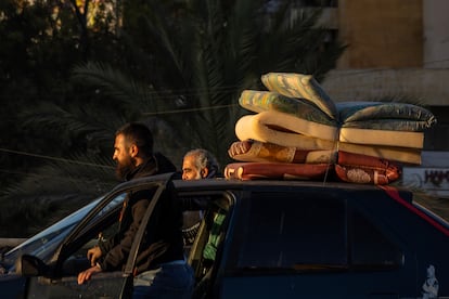 Dos hombres regresan con sus enseres en el coche al barrio del sur de Beirut este jueves. 