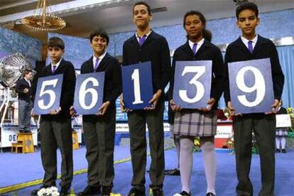 Los niños de San Ildefonso muestran el 'gordo', premiado con 1.600.000 euros la serie.