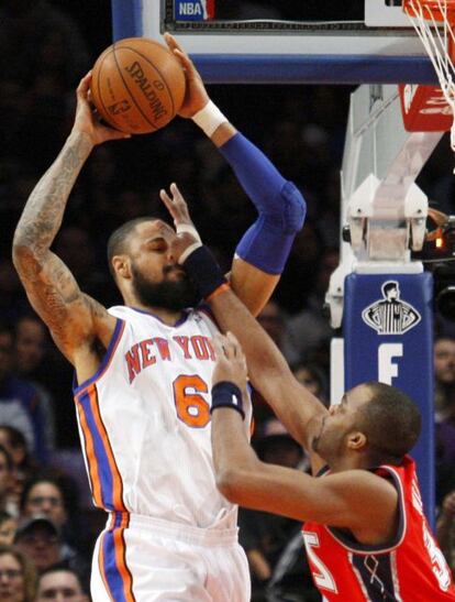 Tyson Chandler (izq.), de los New York Knicks, bloqueado por Shelden Williams de los Nets en el Madison Square Garden.