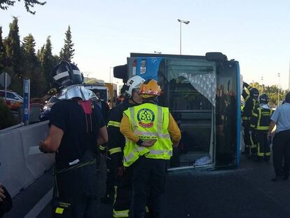 Los servicios de emergencias junto al autobús volcado.