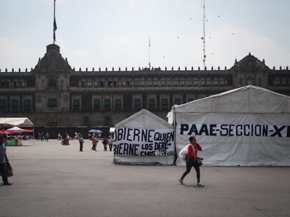 Transeúntes caminan entre el plantón de los maestros de la CNTE frente a Palacio Nacional, en Ciudad de México, el 22 de mayo.