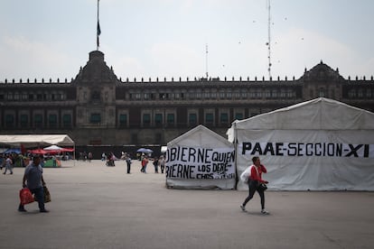 Transeúntes caminan entre el plantón de los maestros de la CNTE frente a Palacio Nacional, en Ciudad de México, el 22 de mayo.