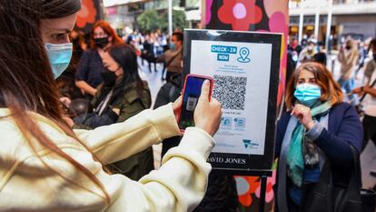 Un cliente escaneando un código QR para ingresar a una tienda en Melbourne, Australia