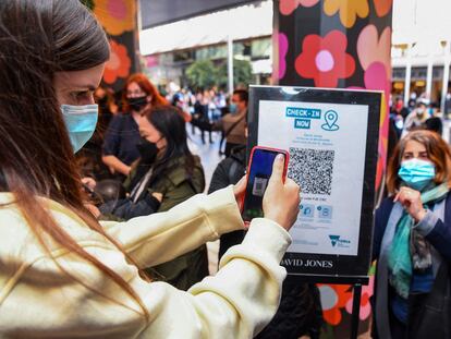 Un cliente escaneando un código QR para ingresar a una tienda en Melbourne, Australia