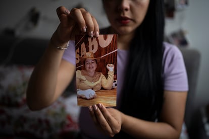 Camila Zapata, sostiene una fotografía de su madre que fue víctima de feminicidio, en su casa en Bogotá, en octubre de 2024.
