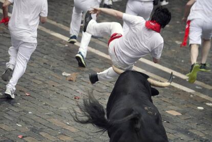 Un corredor es cogido por uno de los toros de la ganaderia salmantina de Puerto de San Lorenzo durante el primer encierro.