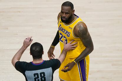 Uno de los árbitros separa a LeBron James de los aficionados con los que mantuvo una discusión durante el Hawks-Lakers.
