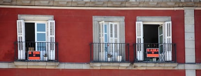 Edificio de viviendas con carteles de alquiler y venta de inmuebles.