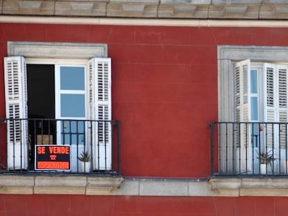 Edificio de viviendas con carteles de alquiler y venta de inmuebles.