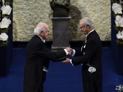 El premio Nobel de Física 2013, Peter W. Higgs, recibe su galardón en manos del rey Carlos XVI Gustavo de Suecia, durante una ceremonia celebrada en la Sala de Conciertos de Estocolmo, el 10 de diciembre de 2013.
