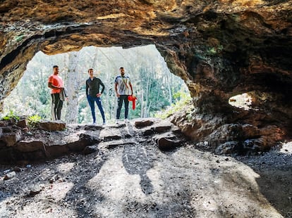 Tres excursionistas en la boca de la cavidad principal de las minas romanas de calcopirita, en Santa María de Trassierra (Córdoba).