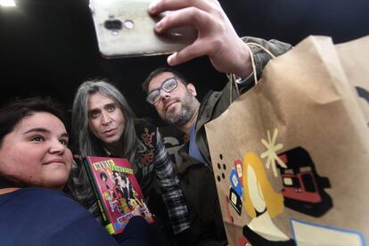 Dos jóvenes se toman una foto con el artista Mario Vaquerizo durante la firma de su libro 'Cuentos para niños rockeros'.