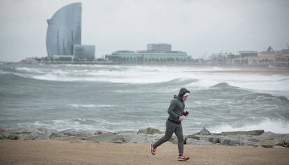 Un 'runner' corre per la plaja de la Barceloneta.