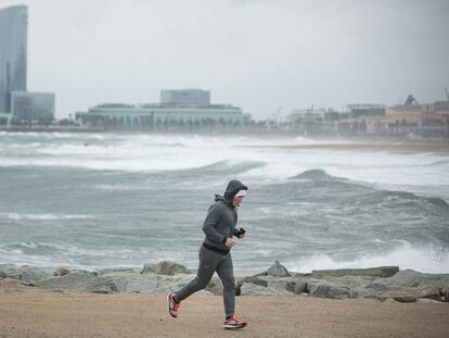 Un 'runner' corre per la plaja de la Barceloneta.