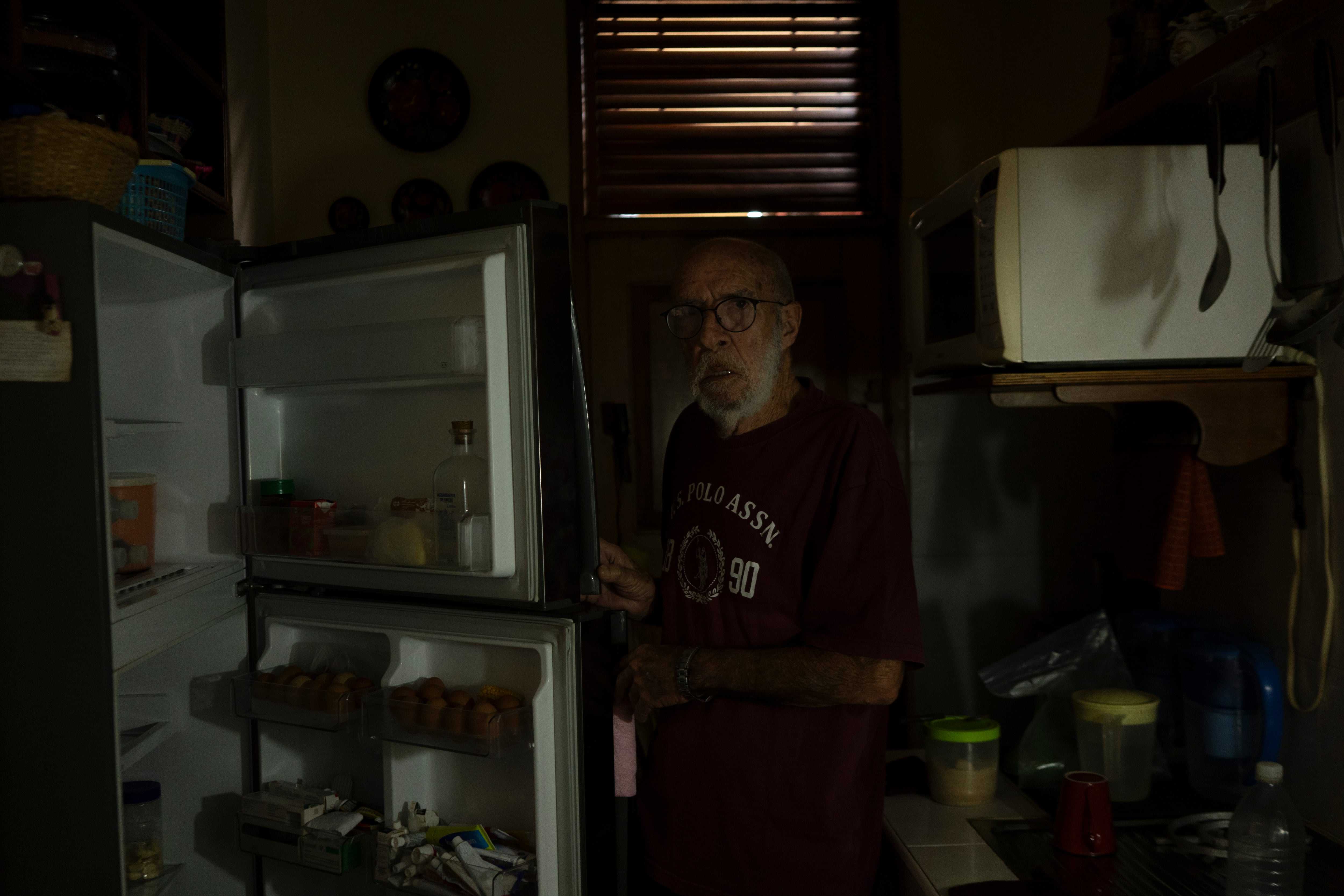 Aurelio abre el refrigerador durante un apagón en el Vedado, en La Habana, el 18 de marzo.