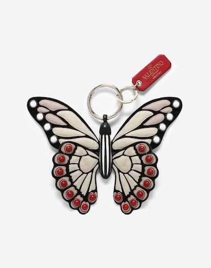 Una mariposa italiana de napa. Una de las empresas de moda con sede en Milán más conocidas, Valentino, ha presentado ya sus últimas novedades, y entre ellas se encuentra este colgante en forma de mariposa. Elaborado en su totalidad con napa, una piel fina curtida con cromo, está fabricado íntegramente a mano y en Italia. Cuenta también con trazas de ante, decoradas con cabujones rojos, negros y blancos, de Valentino Garavani. Dispone de un mosquetón con anilla brisé, con acabado platino y el logo y nombre de la marca serigrafiado. El artículo está diseñado, además, en consonancia con varias de las novedades presentadas también recientemente por la firma. Precio: 590 euros.