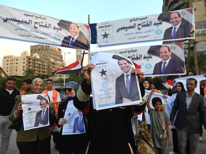 Personas sostienen carteles del presidente egipcio Abdelfatá Al Sisi para celebrar su reelección tras recibir el 89,6% de los votos, este lunes.