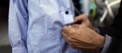 A father buttons up his son’s smock before taking him to school in Madrid.