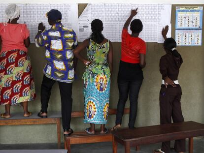 Votantes congoleños buscan sus nombres en el censo en un colegio electoral de Kinshasa.