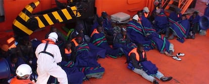Dos operarios de Salvamento Marítimo atienden a los 26 'sin papeles' en aguas del Mediterráneo.