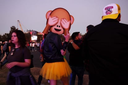 Una asistente al festival camina con una careta que utiliza como disfraz para agregarle humor al evento.
