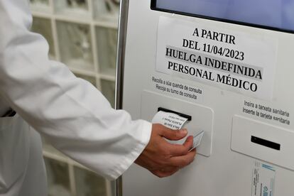 Un médico ayuda a un paciente a conseguir una cita en la máquina en un centro de salud, este martes en Santiago.