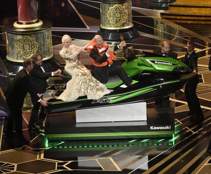 Helen Mirren acompañada de Mark Bridges, ganador del Oscar al mejor diseño de Vestuario, y ganador también de una moto acuática por pronunciar el discurso más corto.