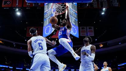 Joel Embiid of the Sixers dunks against Paolo Banchero of the Magic.