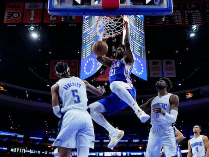 Joel Embiid of the Sixers dunks against Paolo Banchero of the Magic.