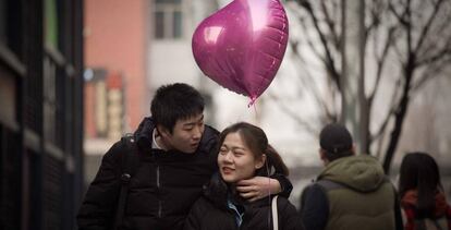 Una pareja camina por Pek&iacute;n el d&iacute;a de San Valent&iacute;n.