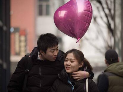 Una pareja camina por Pek&iacute;n el d&iacute;a de San Valent&iacute;n.