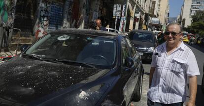 Un hombre junto a un coche dañado tras el terremoto, este viernes en Atenas.