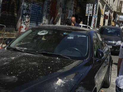 Un hombre junto a un coche dañado tras el terremoto, este viernes en Atenas.