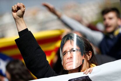 Una mujer con una careta de Puigdemont alza su mano en una concentración este lunes.