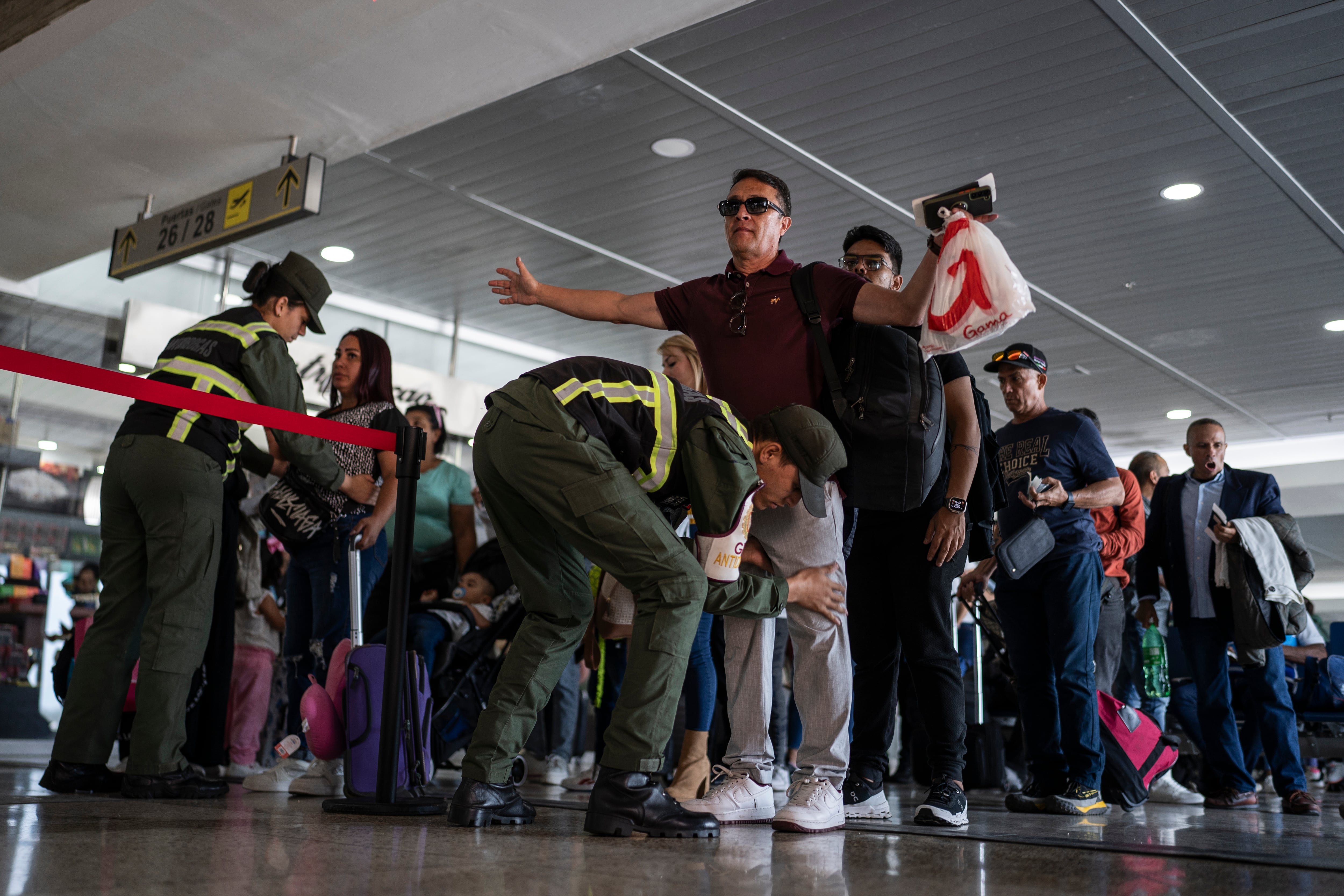 El Comando Nacional Antidrogas de la Guardia Nacional Bolivariana requisa a los pasajeros en el aeropuerto Internacional de Maiquetía Simón Bolívar.