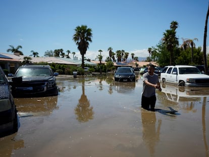 Un hombre vuelve a su casa por una calle inundada, a causa de la tormenta tropical 'Hilary', en Cathedral City, este lunes en California.