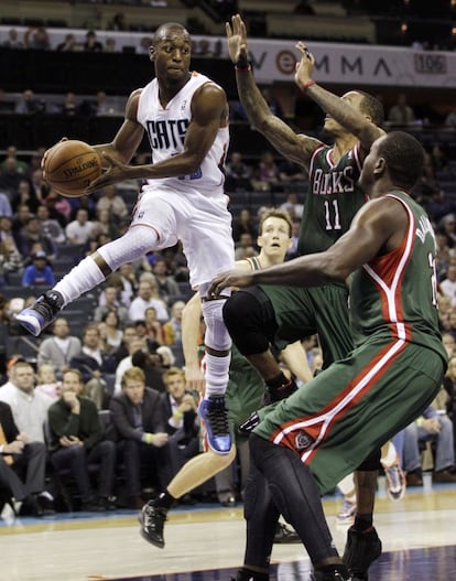 Kemba Walker, de los Bobcats, trata de pasar el balón ante Monta Ellis y Samuel Dalembert, de los Bucks