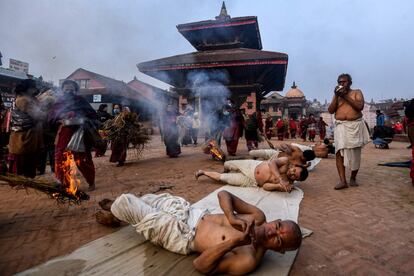 Devotos hindúes ofrecen oraciones rodando por el suelo como parte de un ritual durante el festival Madhav Narayan en Bhaktapur, en las afueras de Katmandú (Nepal).