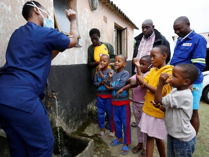 Profissional sanitária no subúrbio de Umlazi, perto de Durban (África do Sul), ensina crianças a lavarem as mãos para deterem o contágio do coronavírus, em 4 de abril.
