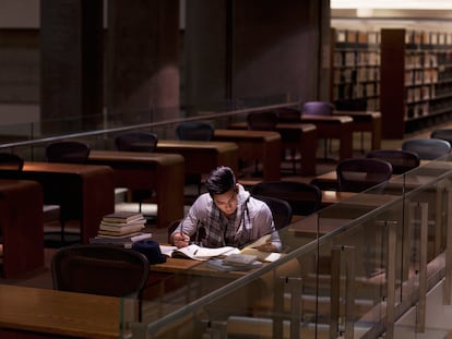 Un joven estudiando en una biblioteca.