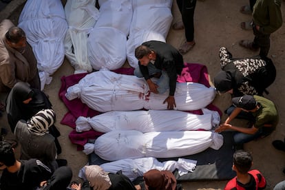 Allegados se reúnen alrededor de cuerpos palestinos que murieron en un ataque aéreo del ejército israelí, 18 de marzo de 2025