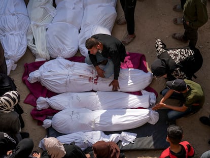 Allegados se reúnen alrededor de cuerpos palestinos que murieron en un ataque aéreo del ejército israelí, 18 de marzo de 2025