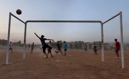 Un grupo de adolescentes juega al fútbol en un campo polvoriento de Islamabad (Pakistán).